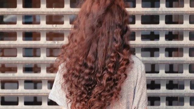 rear View og long haired girl in front of cage