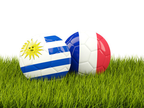 Uruguay vs France. Soccer concept. Footballs with flags on green grass