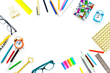 Education background, frame. School, student, office supplies. Stationery, glasses, alarm clock, notebook on white background top view copy space