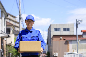 荷物を運ぶ女性配達員