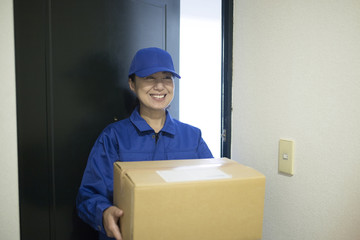 荷物を運ぶ女性配達員