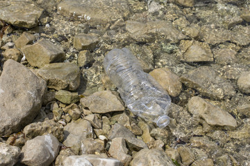 empty water bottle littering lake shore