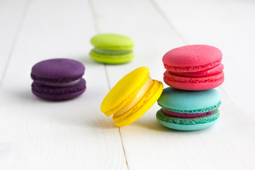 Colorful Macaroons on white wooden background.