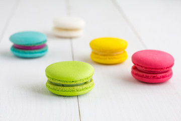 Colorful Macaroons on white wooden background.