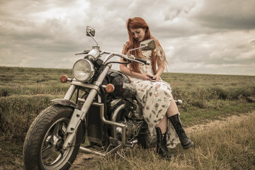 Plakat red-haired girl in a white dress and boots along with a motorcycle. lavender field