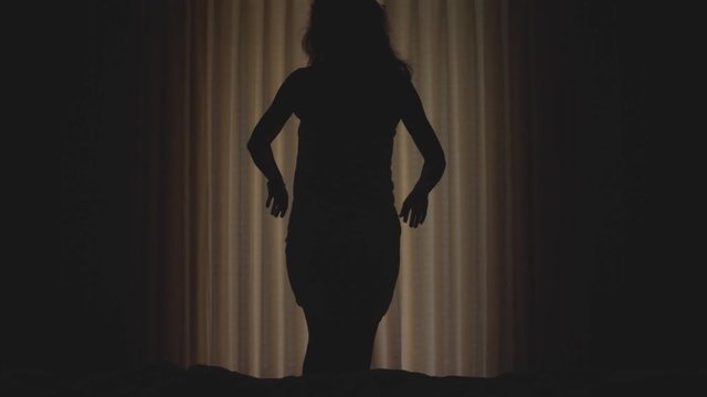 Beautiful girl is wearing white towel opens curtains and goes to sea view terrace. Young woman waking up stretches looking at ocean landscape horizon from balcony. slow motion. 3840x2160