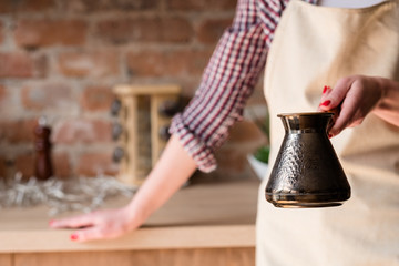 morning coffee tradition. caffeine addiction. strong hot beverage freshly brewed in a jezve or turkish pot in woman hands