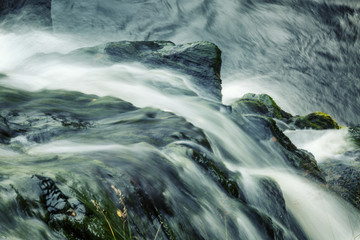A powerful stream of water among the stones, a beautiful waterfall
