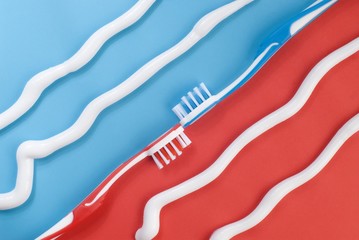 Red and blue toothbrushes on a colorful background