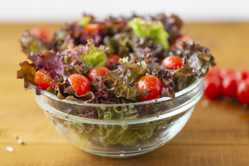 Full bowl of fresh green salad with tomatoes close up. Concept helpful and simple food