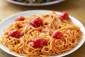 spaghetti with tomato sauce in the dish on the wooden table