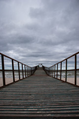 Wooden pier at sea. Gloomy weather.