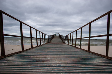 Fototapeta na wymiar Wooden pier at sea. Gloomy weather.