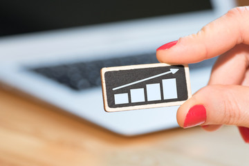 Eine Frau, ein Computer und Symbol für Wachstum