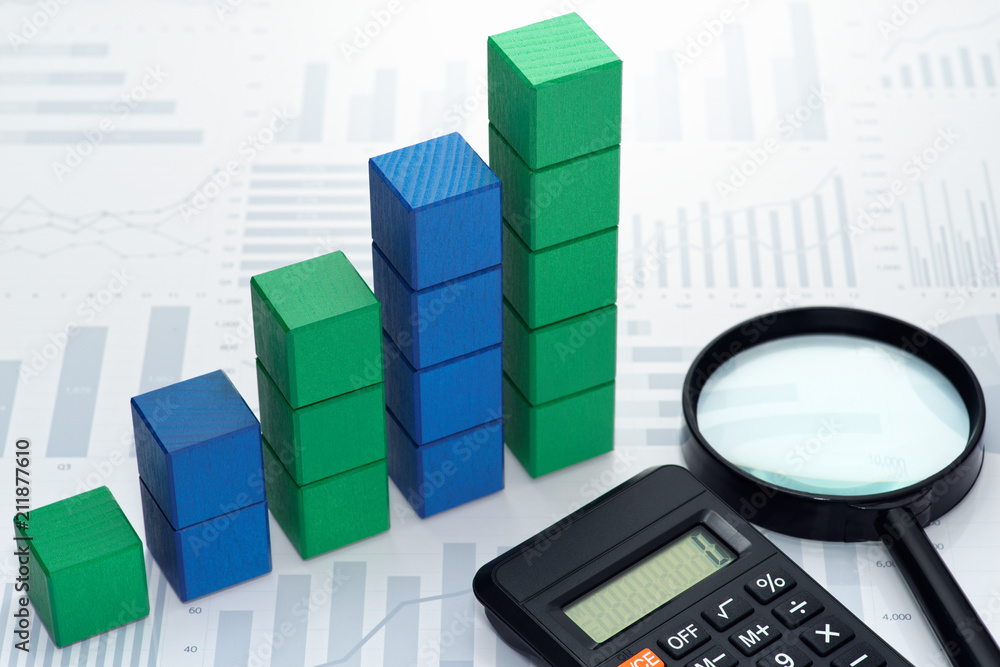 Fototapete Analyzing data. Gathering statistics. Business data processing. Toy block steps, calculator and magnifier on many charts background.
