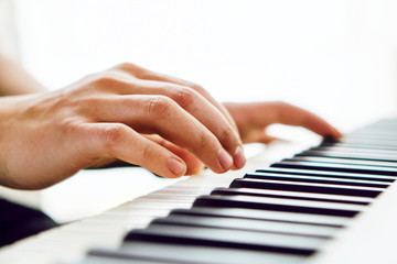 Fototapeta na wymiar Close up of pianists hand playing piano. Shallow deep of field.