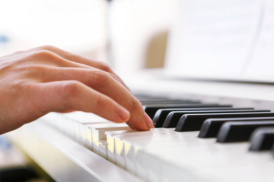 Close up of pianists hand playing piano. Shallow deep of field.