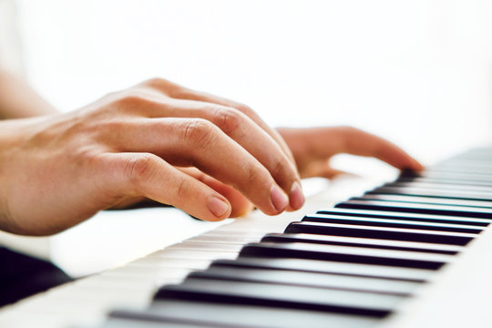 Close up of pianists hand playing piano. Shallow deep of field.