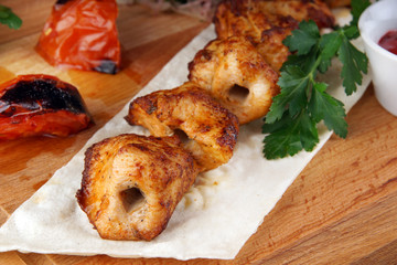 Fried shish kebab from chicken meat with vegetables, pita bread and sauce