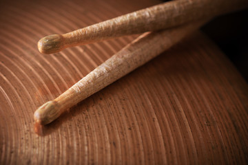 Pair of drumsticks lying on cymbal.