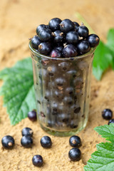 Glass of currant for the preparation of a child's drink smoothies on the river sand traces of rain on the sand