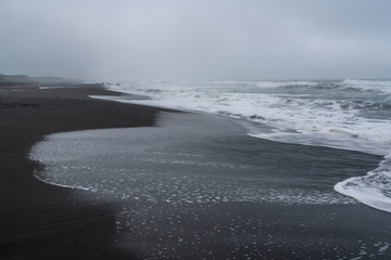 Black volcanic sand at Khalaktyrsky beach of the Pacific at Kamchatka peninsula, near Petropavlovsk-Kamchatsky, Russia