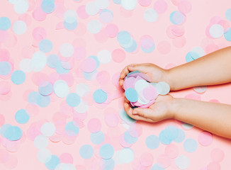 Colorful confetti background with child's hands