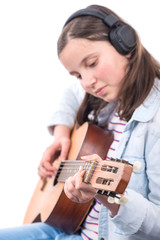 smiling teenager girl playing acoustic guitar on white