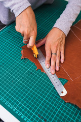 Close up of an artisan working with leather in his laboratory