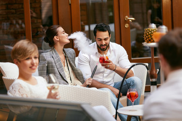 People Smoking Shisha, Drinking Cocktails In Hookah Bar