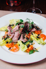 dinner on the table, salad, glass of pink wine, bottle