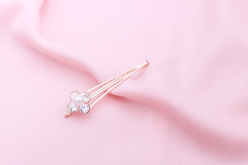 Luxury hair clip on pink fabric with copyspace.