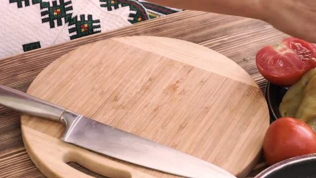 woman hands slicing onions on a wooden cutting board
