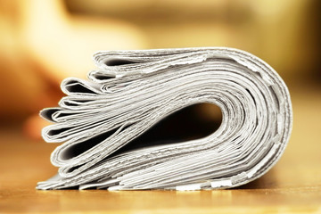 Bunch of folded newspapers on yellow background, side view   