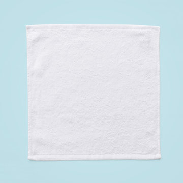 White cotton towel mock up template square size fabric wiper isolated on blue background with clipping path, flat lay top view