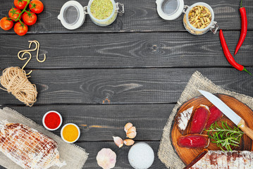 Sliced cured bresaola with spices and a sprig of rosemary.