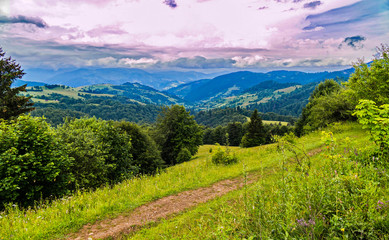 Magnificent mountain scenery a small path and endless clouds floating in the distance