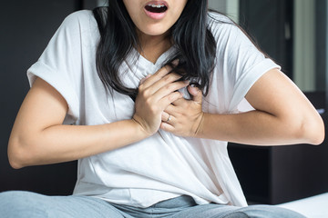 Woman with strong chest pain and hands touching her chest,Heart attack symptom