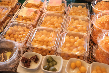 Thai style desserts in plastic boxes.