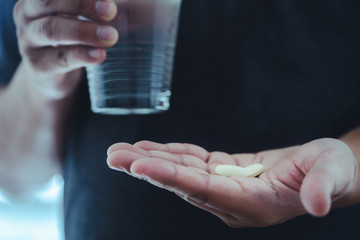 Unhealthy sick Mans hands with pills on healthcare concept treatment
