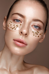 Beautiful fresh girl with cosmetic patches under the eyes, perfect skin and natural make-up. Beauty...
