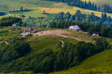 The lift in the mountains with lush greenery. To quickly raise the tourists to the top