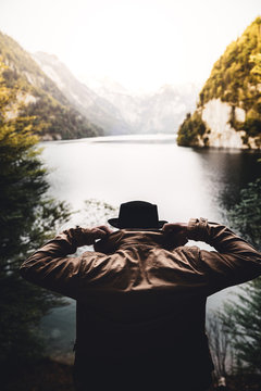 Mann mit Jacke und Hut schaut auf den K&ouml;nigsee beim Sonnenuntergang