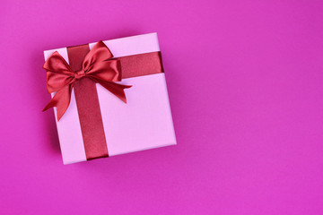 Purple classic gift box with shiny satin bow as attributes of party