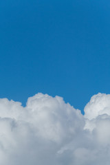 Naklejka na ściany i meble Lush massive white clouds against the background of the endless blue sky