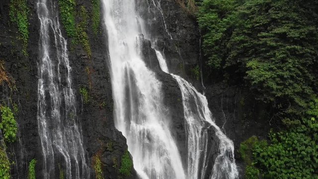 Rising from bottom to the top of beautiful Balinese twin waterfall. Drone shot; Bali, Indonesia