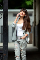 beautiful woman in a gray suit speaks on the phone in the street