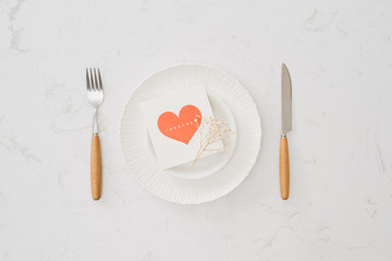 love dinner setting fork and spoon tie with red ribbon on plate on white background , love and romance concept