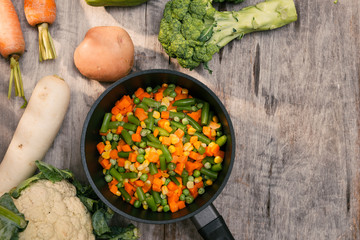 Vegetables Potatoes, Carrots, Cauliflower, Broccoli in pot on wooden table