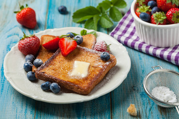 Traditional, delicious, sweet French toast with fruit and butter.